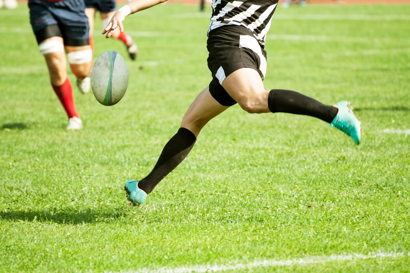 Rugby player kicking the ball